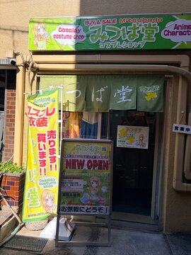 Mitsubado Cosplay Costume Shop exterior with colorful anime banners and signs at the Sato Building in the Akihabara district - Tokyo, Japan, February 21, 2026