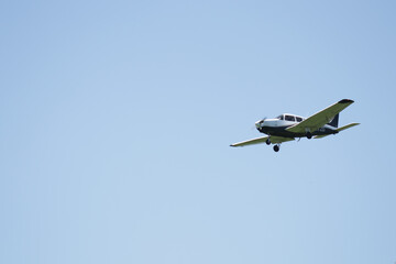 Fototapeta premium Small light aircraft in flight against a blue sky