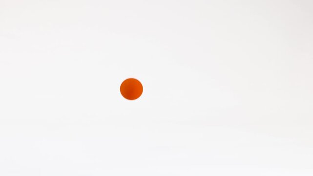Minimalist Orange Ball Bouncing on a Clean White Background