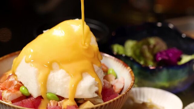 Creamy Yellow Sauce Poured Over Japanese Poke Bowl with White Foam
