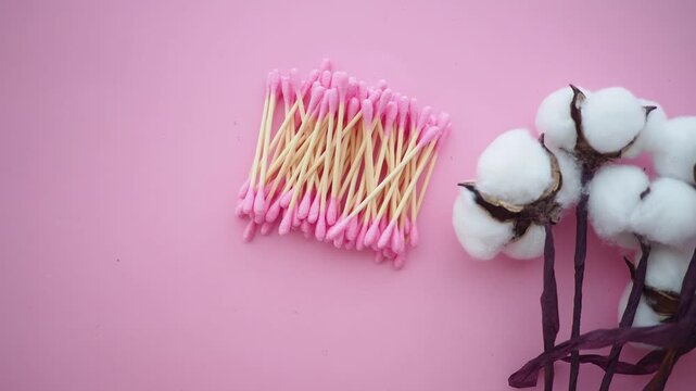 Cotton and cotton swabs on a pink background