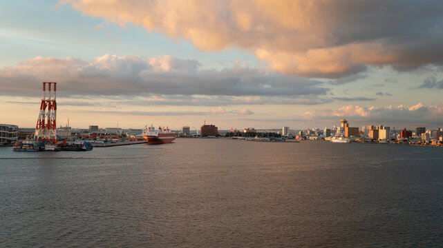 Sunset over industrial port with cargo ship and gantry crane