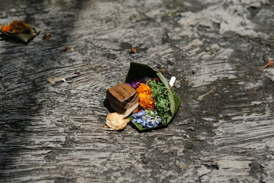 Traditional Balinese Canang Sari Offering Baskets with Colorful Flowers on Ground
