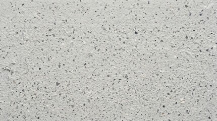 Fototapeta premium Closeup of a light grey concrete wall texture with dark speckles and rough surface