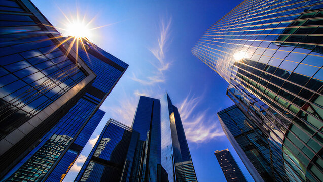 Low Angle View of Glass Skyscrapers and Blue Sky with Bright Sun Flares