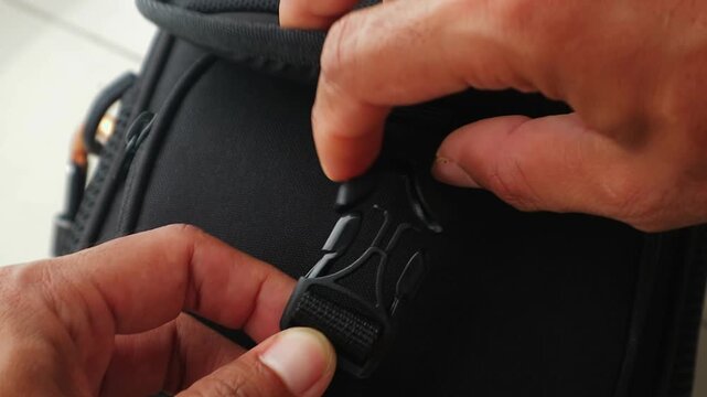 Close Up Hands Opening Black Small Bag Buckle