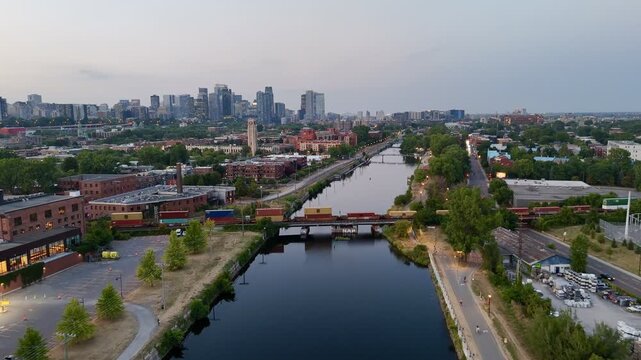 Freight train crossing Lachine Canal at dusk with Montreal skyline and urban waterfront, Quebec, Canada. g.