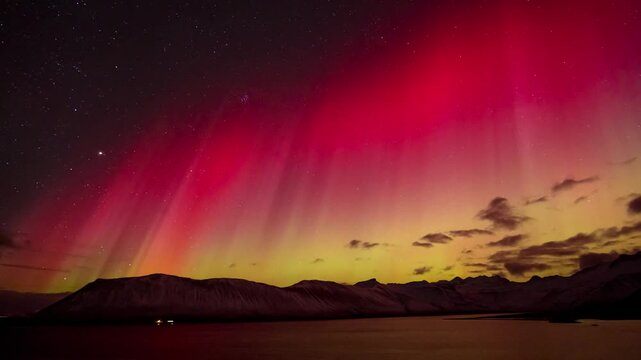 Majestic 4K Horizontal Timelapse of Red and Yellow Northern Lights Shimmering over Snowy Mountains and Arctic Lake in Iceland