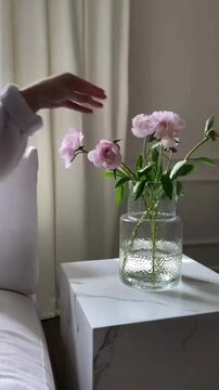 Placing Purple and White Roses Into Clear Glass Vase in Cozy Bedroom Aesthetic Interior