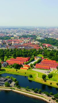 Vertical video. Copenhagen, Denmark. Kastellet, the star-shaped 17th-century citadel with red brick barracks and green ramparts, Drone footage over the harbor and cityscape. Drone footage, Point of i