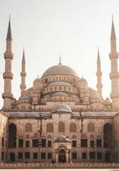 Fototapeta premium Ancient stone mosque with large central dome and tall minarets stands against a bright sky for architectural history, middle eastern travel guides and religious studies