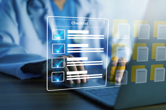 Doctor working with digital checklist and medical documents on laptop for healthcare management and clinical process control