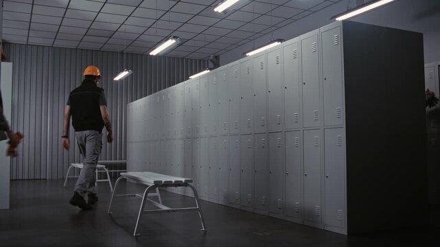 Three Diverse Male Workers in High Visibility Vests and Hard Hats Enter Modern Factory Locker Room to Change Clothes and Talk After Long Day of Work. Concept of Professional Industrial Routine.