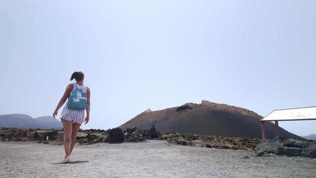 Woman hiking towards El Cuervo volcano in Lanzarote, Spain