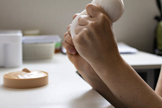 Close up of female hand squeezing a soft sensory squishy toy. Anxiety relief, tactile therapy and stress reduction concept.