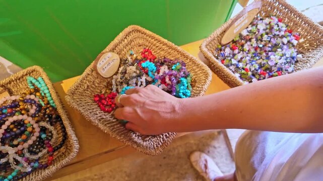 Person choosing a colorful stone bracelet in Teguise market
