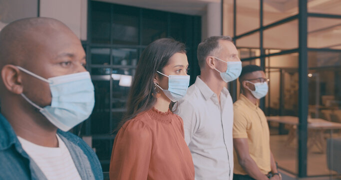 Woman, team and business people in office with mask, safety regulations and virus prevention at night. Late, person and group in workplace with PPE, risk management and protocol for infection control