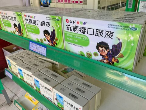 LIJIANG, CHINA - OCTOBER 26, 2017:Boxes of antiviral oral liquid by Jen and Miaka Pharmaceuticals, a Chinese medicine for throat relief displayed on green shelves in a local pharmacy in Lijiang Yunnan