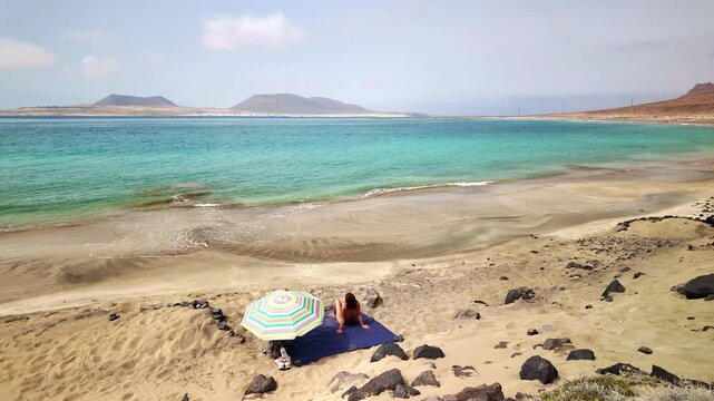 Solitary woman relaxing on Risco beach in Lanzarote