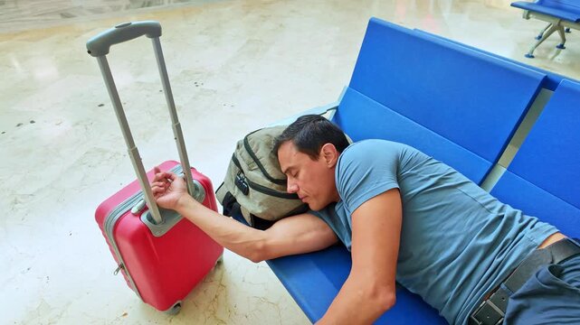 Tired man traveler sleeping on airport bench