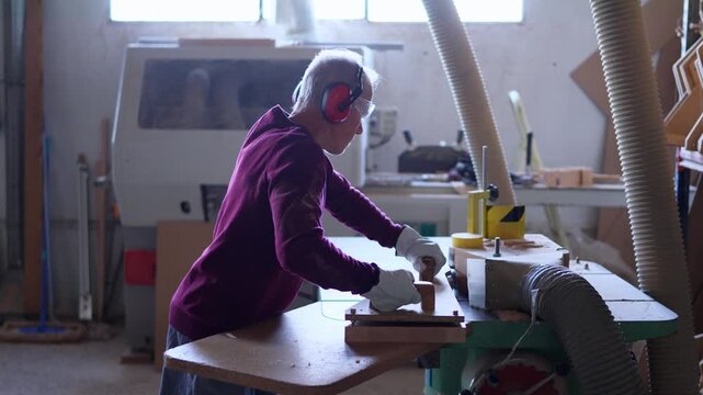 Senior carpenter using a routing table for woodworking