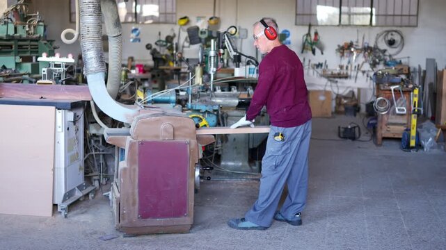 Experienced carpenter using industrial wood sander