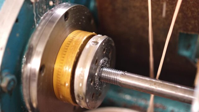 Thread rolling machine creating threads on a metal rod