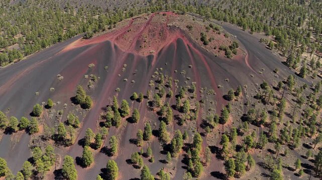 4K drone shot reveals red veined volcanic cinder cone and scoria hill in Arizona. Aerial view shows oxidized mineral streaks, volcanic geography, and rugged desert terrain for nature B-roll.