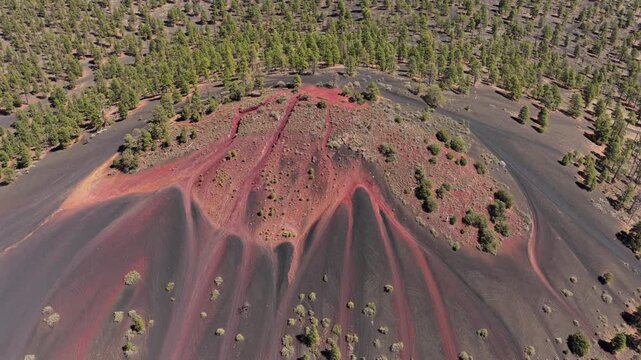 4K drone perspective of red oxidized volcanic cinder hill in the southwestern wilderness. Cinematic flight captures geological formations, arid mountain slopes, and unique Arizona geology.