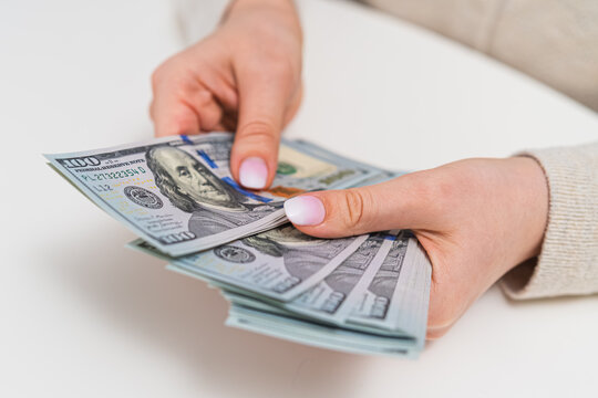 Woman organizing dollar banknotes. Income tracking, budgeting and financial responsibility concept.