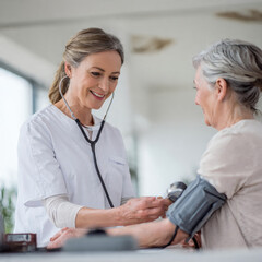 Fototapeta premium Nurse measuring blood pressure of patient in minimal clinic setting