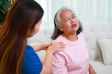 Fototapeta premium Physical therapist massaged senior patient shoulder. Geriatric rehabilitation and home care service. Concepts of elderly healthcare.