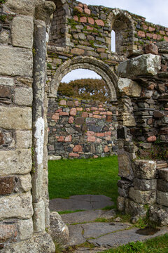 View of Iona Nunnery featuring ancient stone walls and a Romanesque arch overlooking green grass Baile Mor, Scotland, United Kingdom.