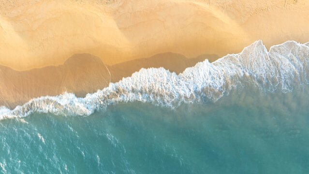 Natural coastal background showing ocean waves flowing across sandy beach from aerial perspective. Ideal visual for tourism marketing, holiday branding, and tropical lifestyle design.
