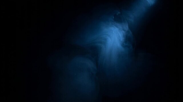 Blue Atmospheric Light Beam with Drifting Volumetric Smoke in Darkness