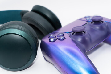A gamepad for consoles and headphones on a white background, gaming addiction, gaming ban for teenagers, gaming controls for parents, for banners and advertising. High quality © Karen Vardanian