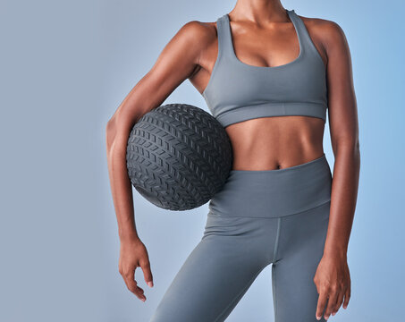 Fitness, medicine ball and abs with woman in studio for health, gym equipment and workout challenge. Wellness, training progress and exercise with person on background for body care and commitment