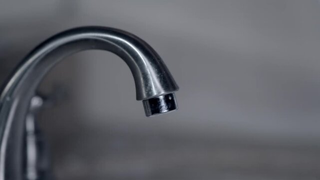 Household water conservation concept with running kitchen sink tap