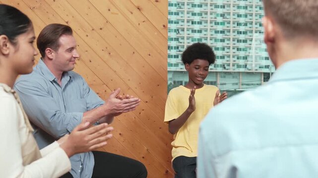 Multicultural people clapping hands to encourage in group therapy. Happy diverse student clap hand together while caucasian teacher looking at children. Creative activity concept. Edification