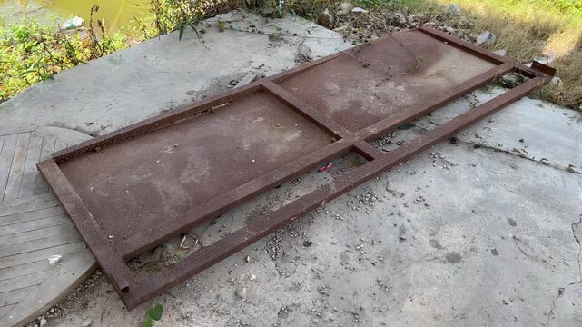 Old rusty metal gate lying on the concrete floor