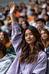 Fototapeta premium Young woman raising hand while seated in crowded lecture hall
