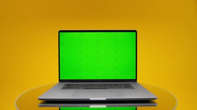 Laptop with green screen on yellow background