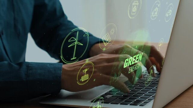 Hands typing on laptop with green energy icons and symbols illustrating sustainable technology and eco-friendly practices in modern workspace. Cipher