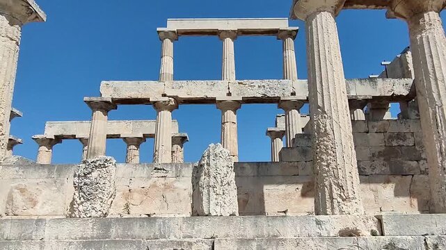 The Temple of Aphaia on Aegina island, Greece, a well preserved temple featuring impressive Doric columns and intricate sculptural details from around 500 BCE, overlooking the the Saronic Gulf