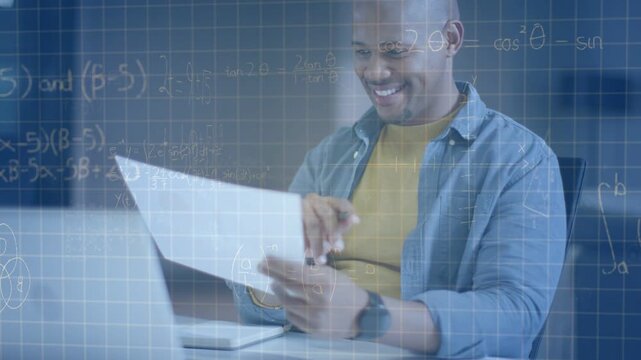 Man at desk glancing at laptop, verifying calculations and marking paper as grid math overlays