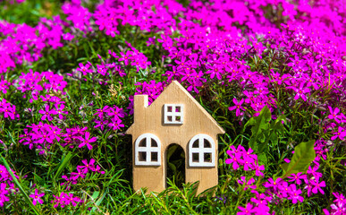 Naklejka premium The symbol of the house on the background of purple flowers 