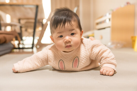 うつ伏せでカメラを見つめるうさぎ柄ロンパースの日本人の男の赤ちゃん