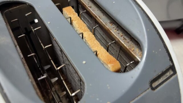 toaster with glowing heating elements preparing bread, kitchen appliance in use, breakfast cooking concept, home lifestyle scene