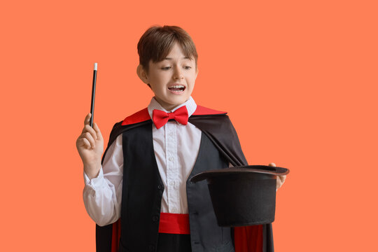 Little magician with wand and hat on orange background