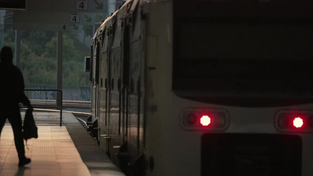 Train arrives at platform during early morning hours at city station